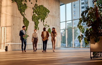 group of corporate employees walking together having a conversation in a building lobby.