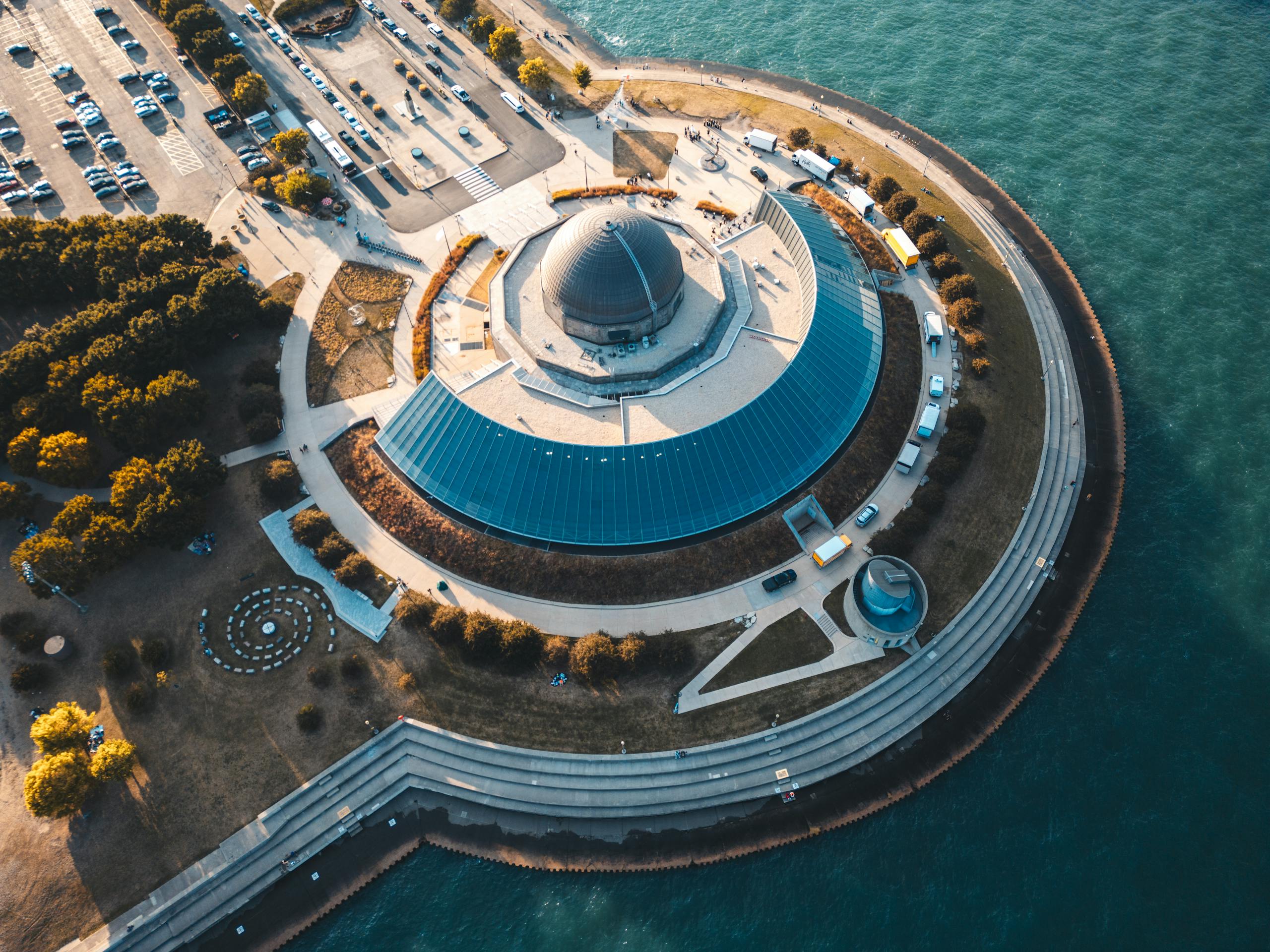 A stunning aerial view of Adler Planetarium Chicago surrounded by water and green landscapes.