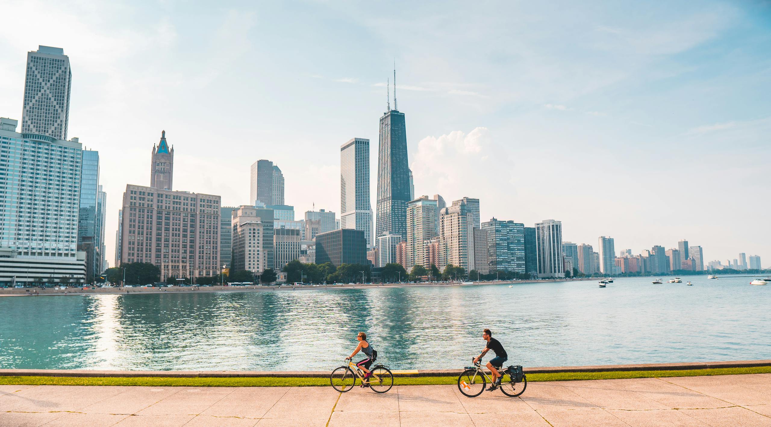 Cyclists biking along the Chicago waterfront with a stunning skyline view.